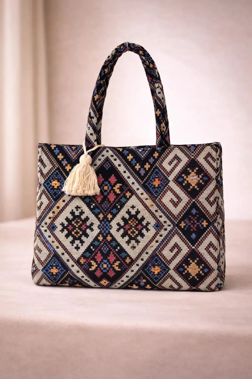 Tote bag with geometric pattern and tassel on a beige background BY ENSAC
