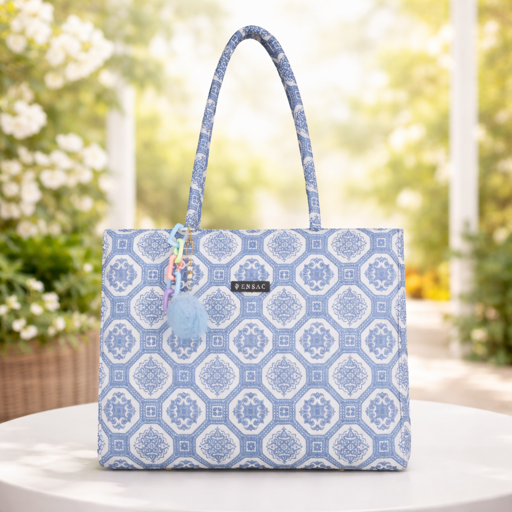 Woman holding a blue patterned tote bag by a poolside BY ENSAC