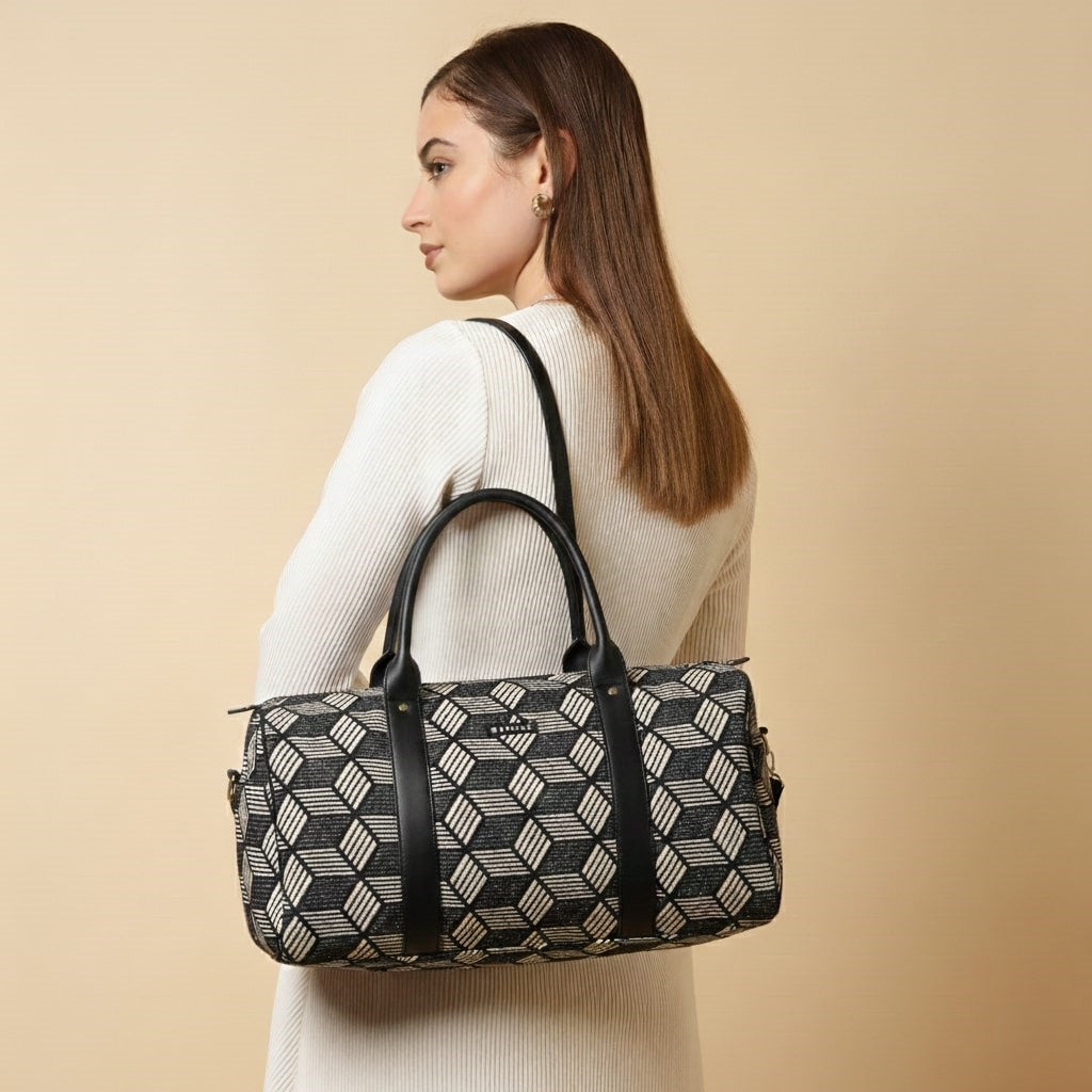 Woman carrying a patterned handbag against a beige background by ENSAC