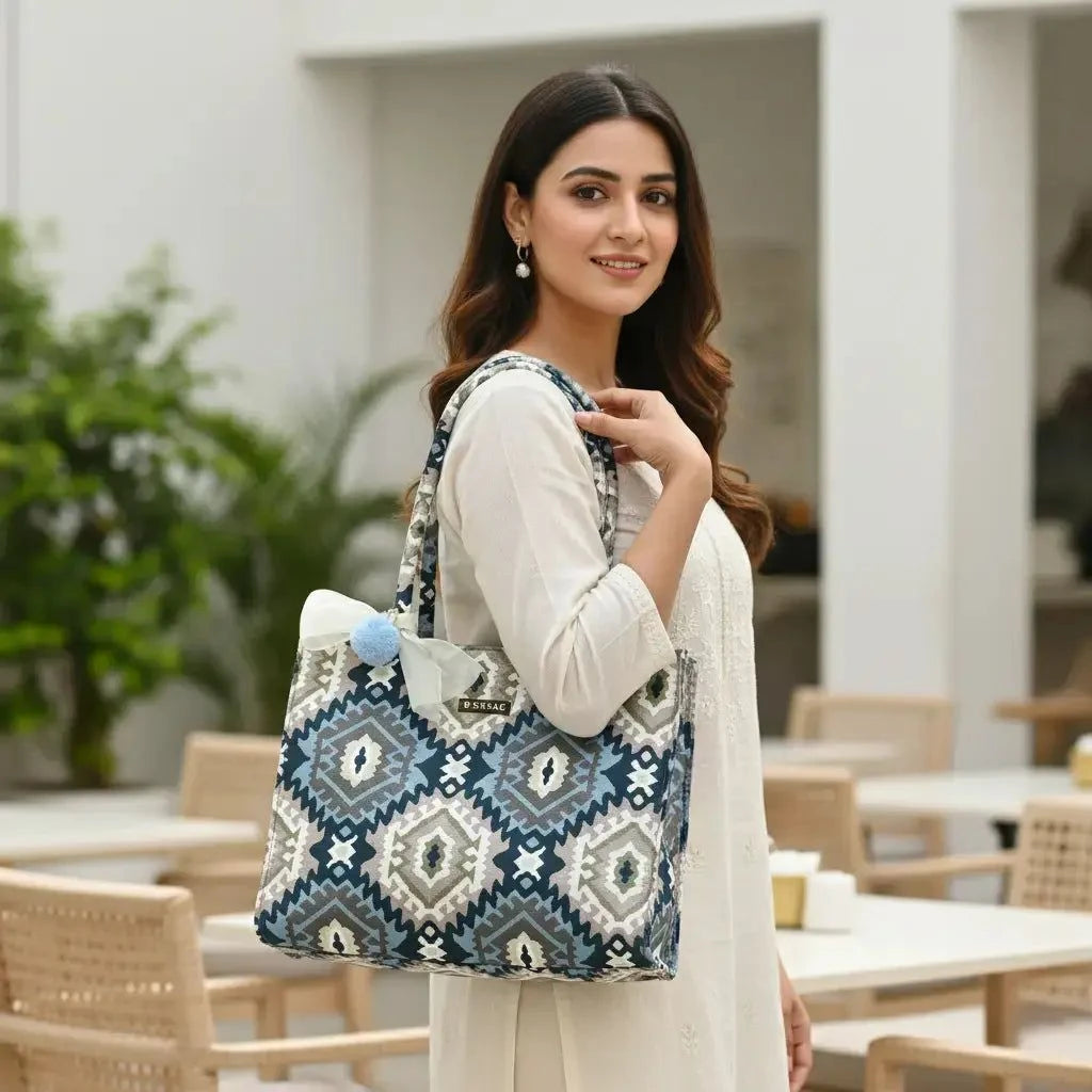 Woman holding a patterned tote bag in an outdoor setting BY ENSAC