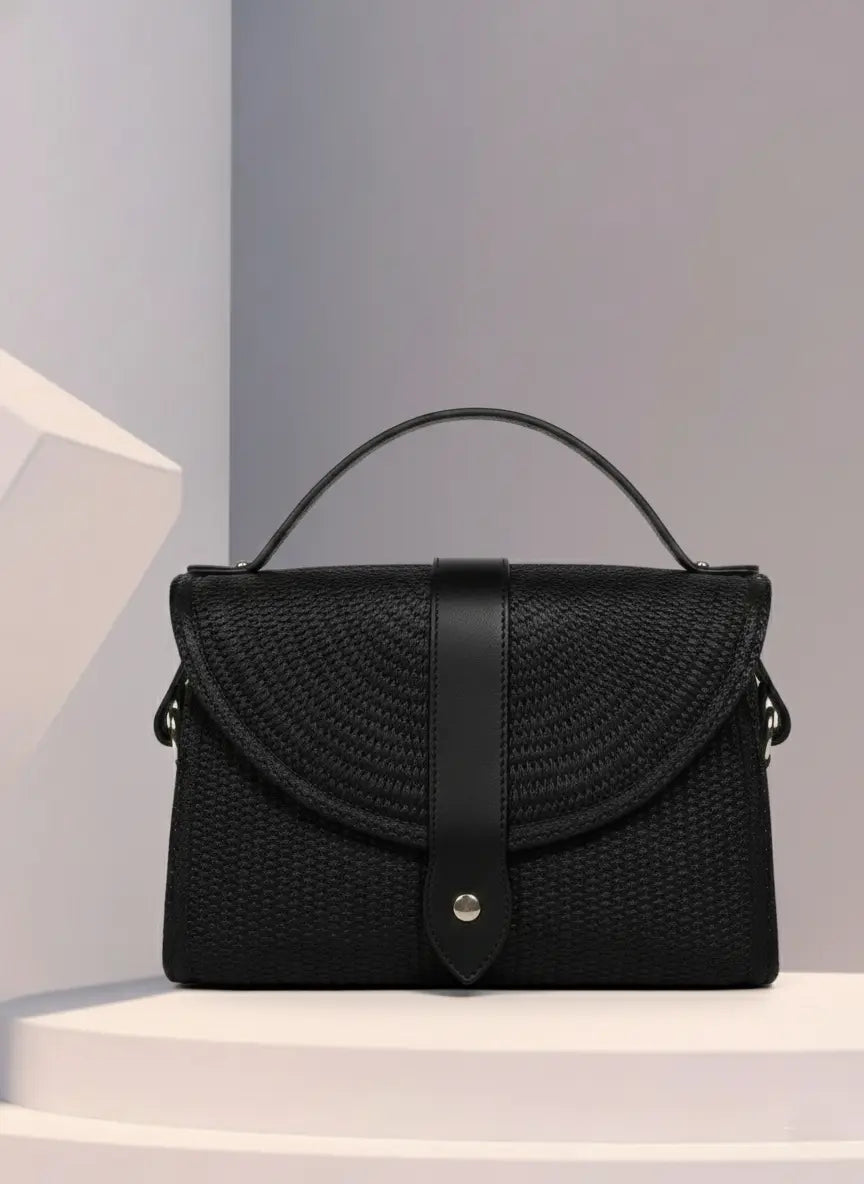 Black woven handbag on a white platform with a gray background by ENSAC