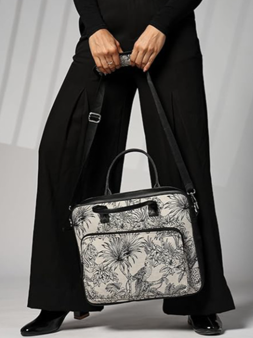 Person holding a floral-patterned handbag against a plain background