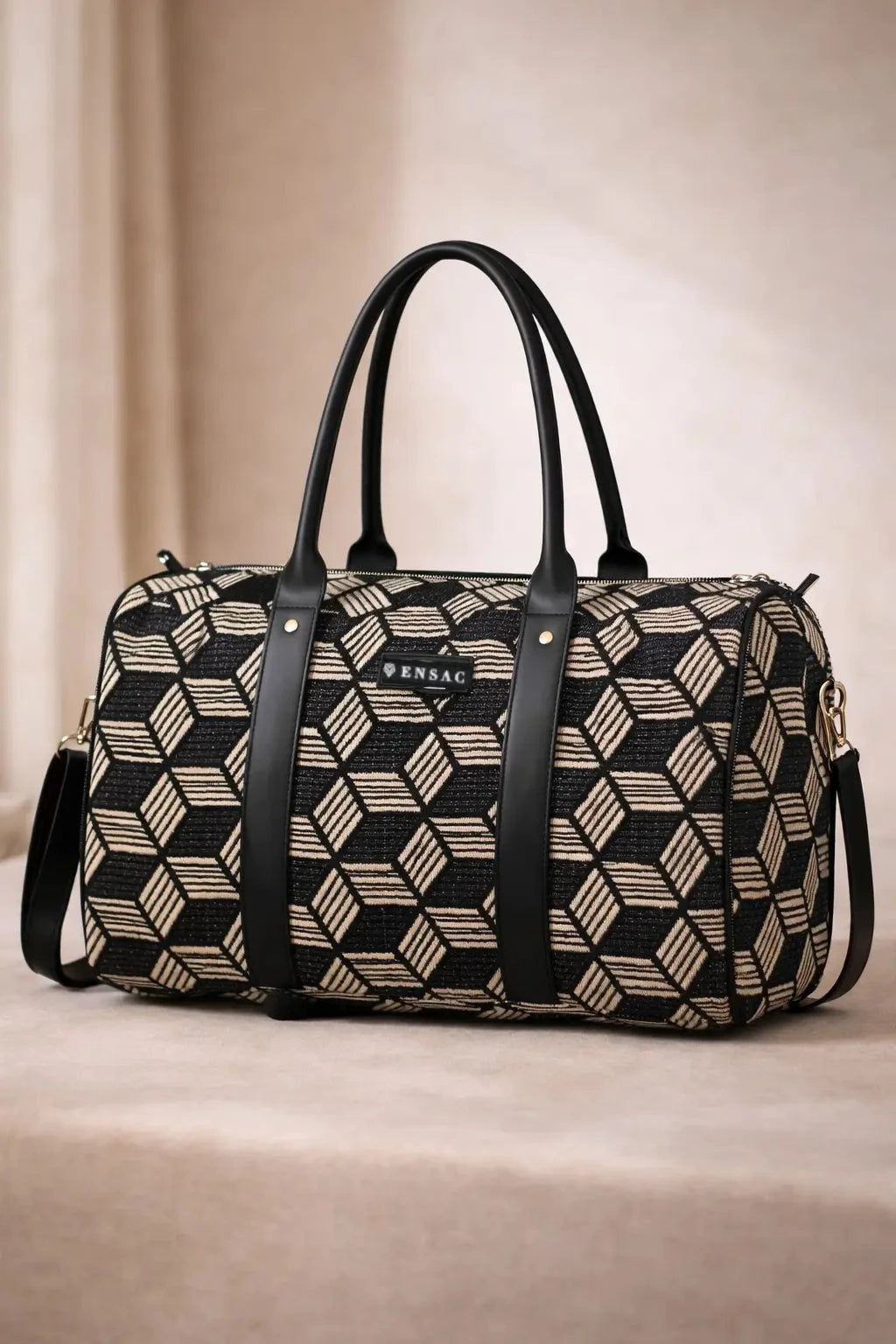 Patterned duffel bag with black straps on a beige background BY ENSAC