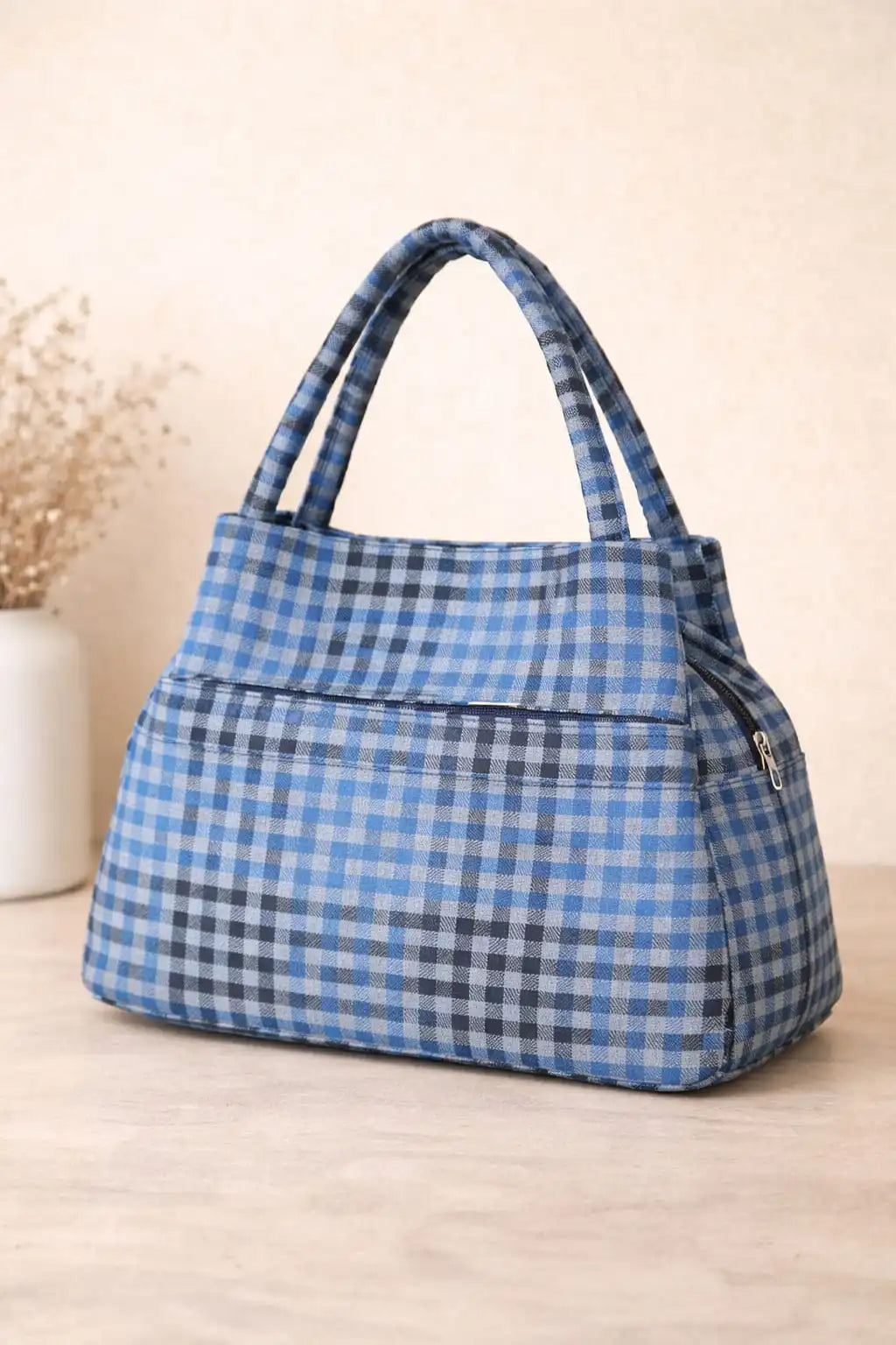 Blue and white checkered handbag on a light wooden surface