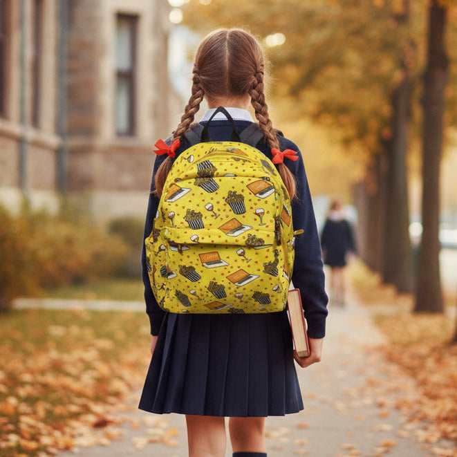 Girl with a yellow backpack walking on a school path in autumn.