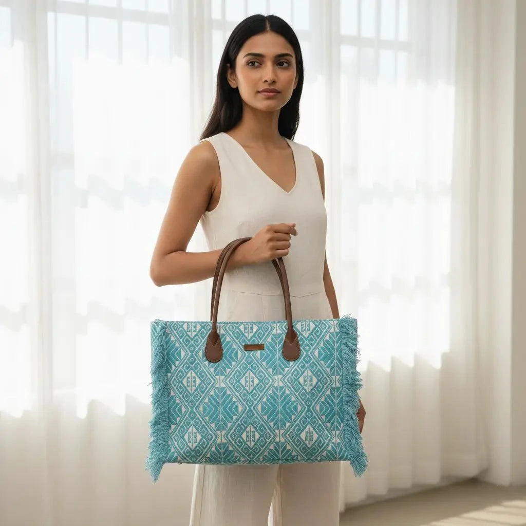 Woman holding a blue patterned tote bag in front of white curtains